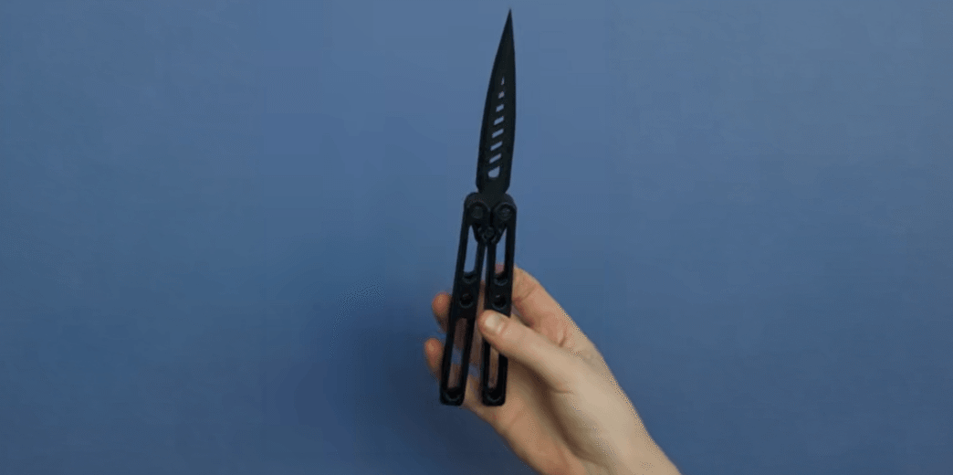 A hand demonstrates a 3D-printed butterfly knife as part of The Beam's investigation into untraceable weapons in Arizona schools