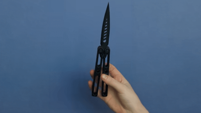 A hand demonstrates a 3D-printed butterfly knife as part of The Beam's investigation into untraceable weapons in Arizona schools