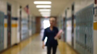 teacher walking in classroom hallway from storyblocks