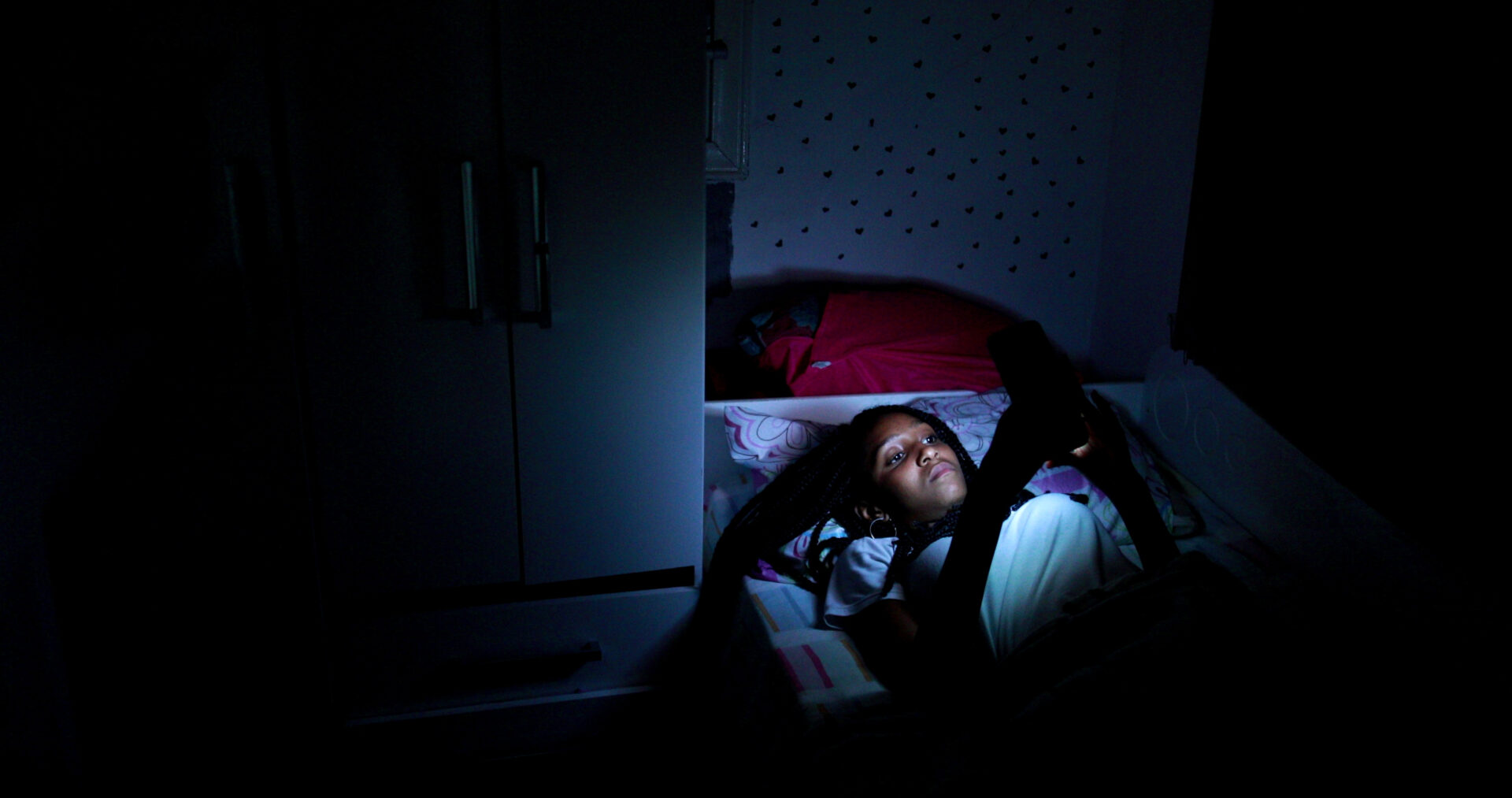 Storyblocks: Still Image of Teen Black Girl Using Cellphone Device At Night In Bed